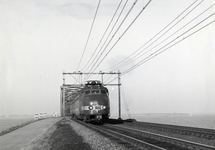 168251 Afbeelding van een electrisch treinstel mat. 1957 (Benelux) van de N.S./N.M.B.S. nabij de spoorbrug over het ...